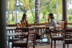two women sitting at a table in a restaurant at Merumatta Senggigi Lombok in Senggigi
