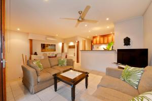 a living room with two couches and a table at Seascape Holidays Villa 8 Surya in Port Douglas
