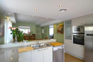 a kitchen with white cabinets and a sink at ARENDA Pino Alto Villa Gallo in Miami Platja