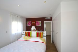 a bedroom with a white bed with a red and yellow blanket at ARENDA Pino Alto Villa Gallo in Miami Platja +49 photos