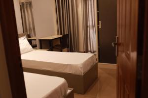 a hotel room with two beds and a desk at Grace Apart Hotel @Kochi in Cochin