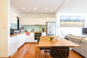 een keuken en eetkamer met een houten tafel bij Laaqua in Blueys Beach