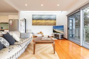 een woonkamer met een bank en een tafel bij Laaqua in Blueys Beach