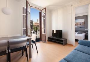 sala de estar con mesa, sofá y TV en AB Marina Apartments, en Barcelona