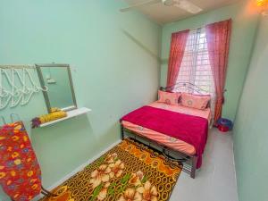 a small bedroom with a bed and a mirror at Nail Homestay Kuala Besut in Kuala Besut