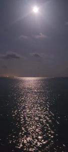 a full moon over the ocean at night at Cabaña Buenos Aires in Palomino