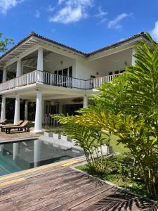 a villa with a swimming pool and a house at Good Vibes Villas in Unawatuna