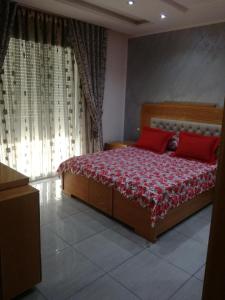 1 dormitorio con 1 cama con 2 almohadas rojas en s 2 1 km from the beach mansoura kelibia, en Kelibia