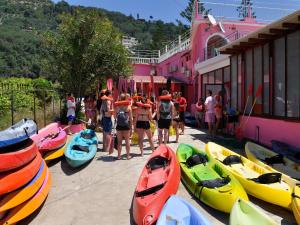 a group of people standing next to a group of kayaks at Pink Palace Beach Resort in Agios Gordios