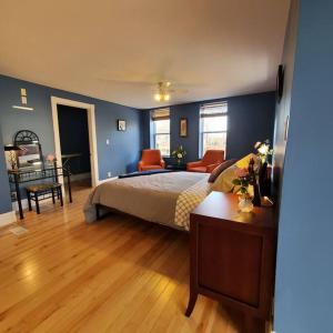 um quarto com paredes azuis, uma cama e uma mesa em Garden 2 Storey House em Cataratas do Niágara