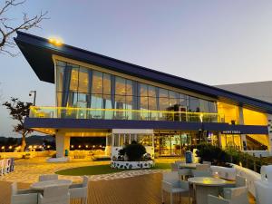 een gebouw met witte stoelen en tafels ervoor bij Sol Beach Samcheok in Samcheok