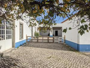 una casa blanca con una pared azul y un camino de entrada en Pátio Sant'Ana - 2 bedrooms villa w/ exterior area, en Sesimbra