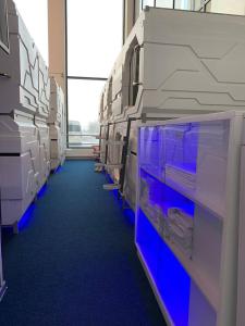 an empty room with blue carpet and white shelves at CAPS LOCK Airport Hotel in Astana