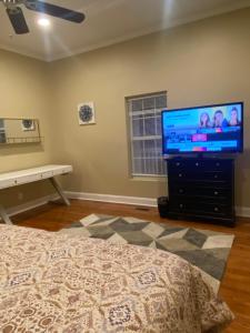 um quarto com uma televisão de ecrã plano numa cómoda em Modern home with huge fenced yard and No pet fees em Durham