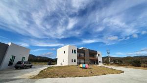 a building with people sitting on the grass in a parking lot at Clare Holiday B&B in Checheng