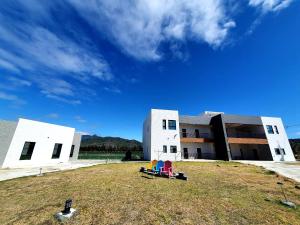 a building with two chairs on the grass in front of it at Clare Holiday B&B in Checheng