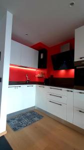 a kitchen with white cabinets and red walls at Grand Bijoux in Breuil-Cervinia