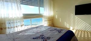 a bedroom with a bed and a large window at Sweet Honeymoon Apartment Tel Aviv Bat Yam 611 in Bat Yam
