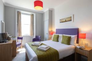 波特帕特里克The Portpatrick Hotel by Compass Hospitality的一间卧室，配有一张床和一张带电脑的书桌