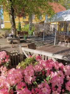 un ramo de flores rosas delante de una mesa de madera en Jelling Kro en Jelling