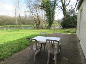 una mesa blanca y sillas en un patio en Hébergement canal, en Villeder