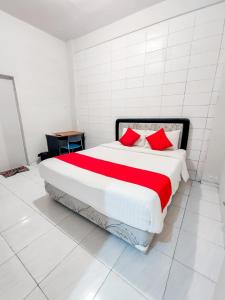 a bedroom with a large bed with red pillows at Kozy 15 Guesthouse in Surabaya