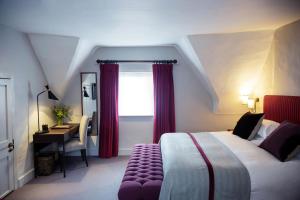 a bedroom with a bed and a desk and a window at Old Parsonage Hotel in Oxford