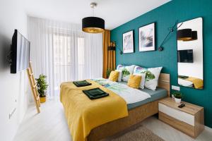 TELEKI40 Apartman Győr CENTRAL, FREE PARKING, TERRACE في جيور: غرفة نوم بسرير مع جدار ازرق