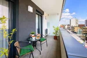 a balcony with a table and chairs and a view at TELEKI40 Apartman Győr CENTRAL, FREE PARKING, TERRACE in Győr