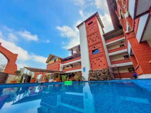 een hotel met een zwembad voor een gebouw bij Ansh Resort, Dandeli in Dandeli