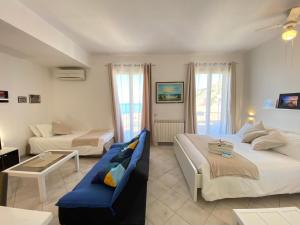 a hotel room with two beds and a couch at Ma&Mi Guest House in Cefalù