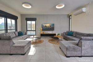 uma sala de estar com dois sofás e uma mesa em וילה מגדלא em Migdal