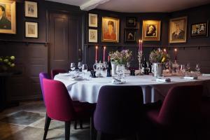a dining room with a table with wine glasses at Old Parsonage Hotel in Oxford
