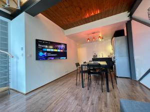 a dining room with a table and chairs and a tv at Pere Lachaise Apartment in Paris