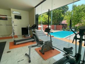 a gym with cardio equipment and a swimming pool at Holiday Resort - SHA Plus in Ko Yao Noi