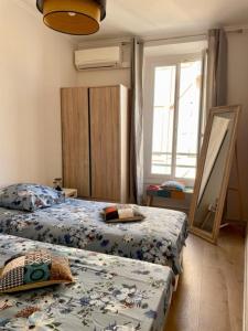 尼斯的住宿－Un havre de paix et de calme en plein centre de Massena，一间卧室设有两张床和窗户。