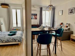 uma sala de estar com mesa e cadeiras e uma sala de estar em Un havre de paix et de calme en plein centre de Massena em Nice
