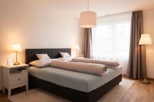 a bedroom with a large bed and a window at Senevita Ahornpark in Bätterkinden