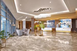 a lobby of a hotel with chairs and plants at Kingsford Hotel Manila Bay in Manila +36 photos
