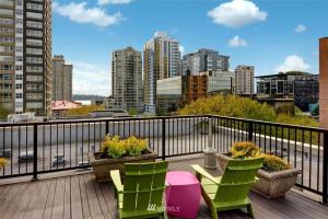 a balcony with a table and chairs and a view of a city at Lovely 1 Bedroom Condo in the Heart of Seattle! in Seattle