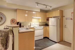 a kitchen with a white refrigerator and a sink at Lovely 1 Bedroom Condo in the Heart of Seattle! in Seattle