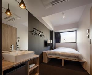 a bedroom with a bed and a sink and a tub at Piece Hostel Sanjo in Kyoto