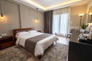 a hotel room with a large bed and a desk at Agnantio Hotel & Spa in Sidirokastro