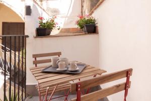 una mesa con dos tazas en una bandeja en un balcón en Aragona15 Suites, en Palermo