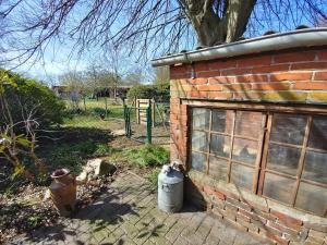 two trash cans next to a brick building at Ferienhäuschen Alte Schmiede, 35647 in Uplengen