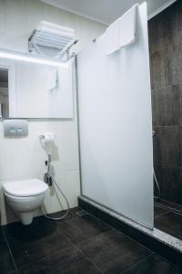 a bathroom with a toilet and a shower stall at Colosseum Marina Hotel in Batumi