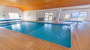 a large swimming pool with a large blue pool at Clifton Court Apt 15 with Indoor Heated Pool in Croyde