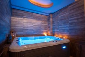 a bathroom with a blue tub with candles in it at Agnantio Hotel & Spa in Sidhirókastron