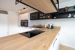 a kitchen with white cabinets and a wooden counter top at Alpenaster 2 in Sonthofen