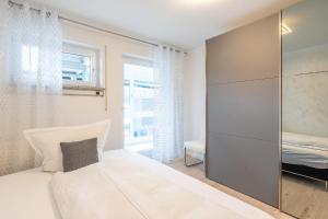 a bedroom with a large white bed and a window at Alpenaster 2 in Sonthofen +1 photo